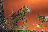 Wat Xieng Thong temple in Luang Prabang, Laos. Detail of the famous tree of life mosaic of the back wall of the sim, in colored glass on a dark red background.